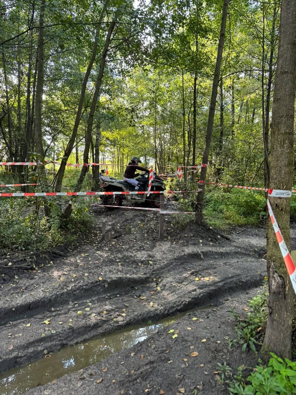 Quad pokonujący błotnisty odcinek w strefie leśnej toru Waganka 4x4